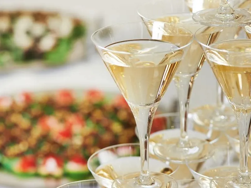 Gäste einer Geschäftseröffnung mit Fingerfood und Schaumwein