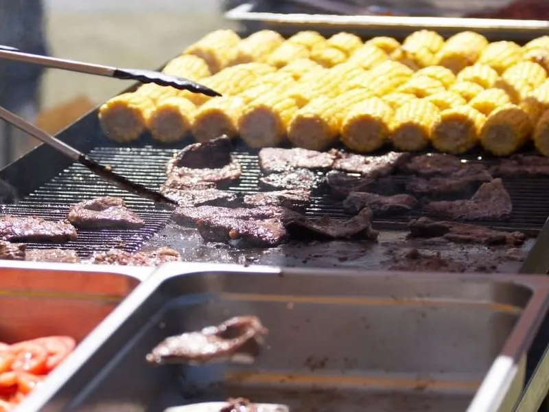 Sommerliche Grillstation für eine Firmenfeier im Freien mit Lichterketten Sommerliche Grillstation für eine Firmenfeier im Freien mit Lichterketten