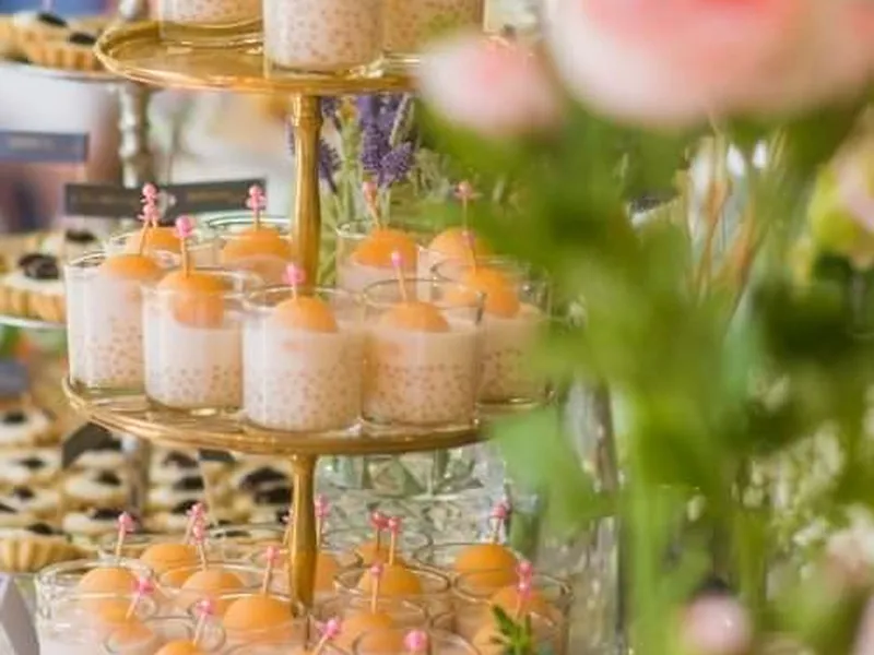 Nahaufnahme einer gedeckten Tafel mit Blumenschmuck und Stoffservietten