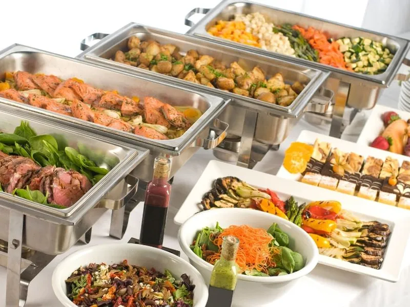 Dampfende Speisen auf einem warmen Buffet bei einer Feier