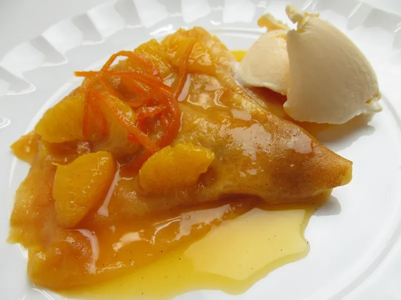 Crêpe Suzette mit Orangenfilets und Vanilleeis, flambiert