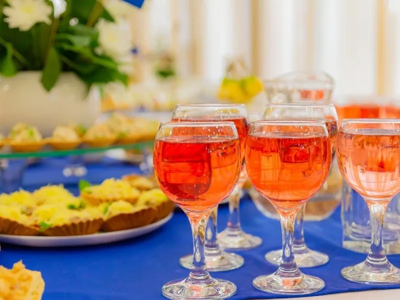 Gäste am Stehtisch mit Champagner und Fingerfood