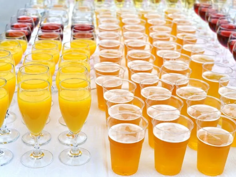 Gläser auf einer Catering-Bar, in eines wird Sekt eingeschenkt